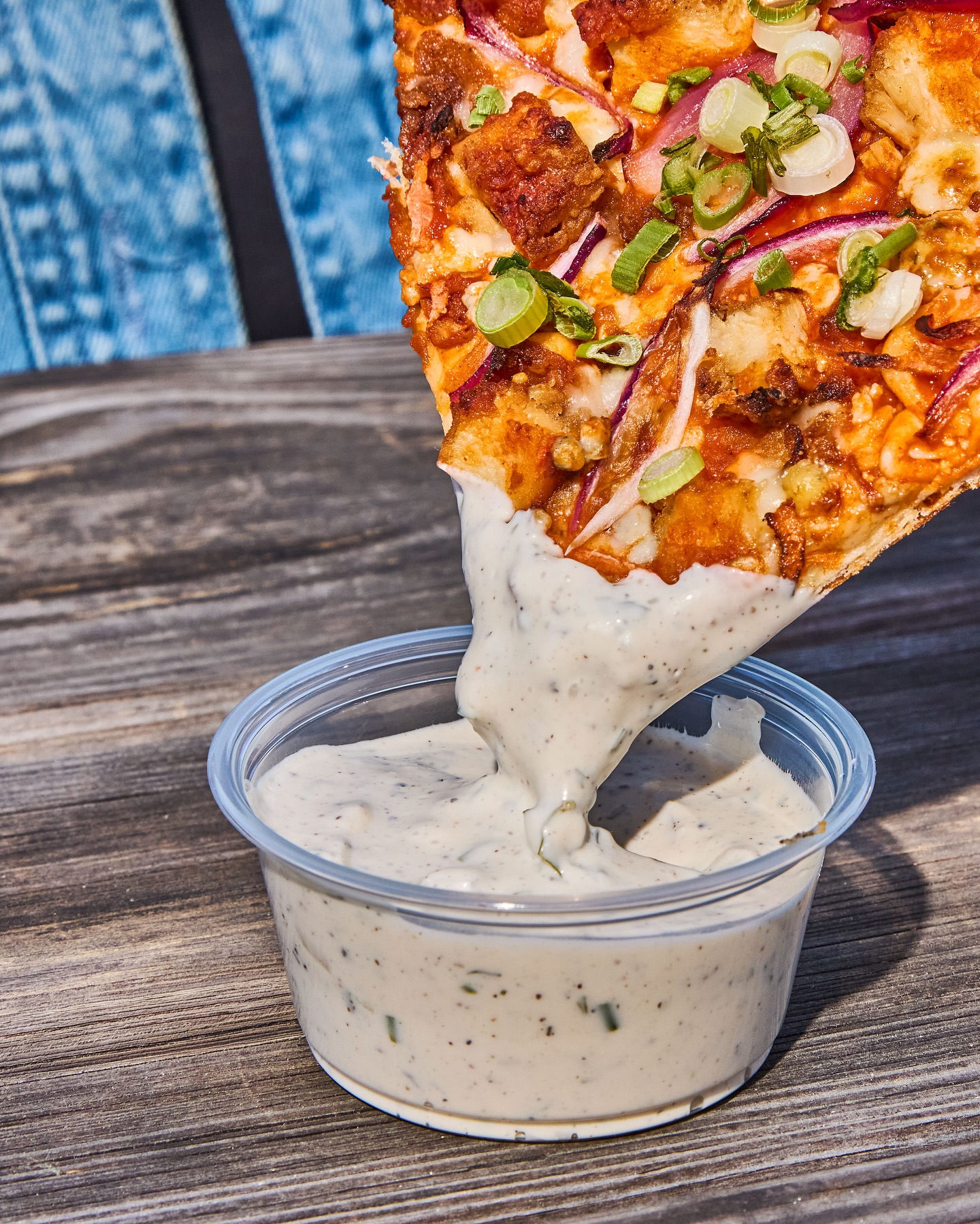 Dipping a buffalo wing pizza in some creamy ranch